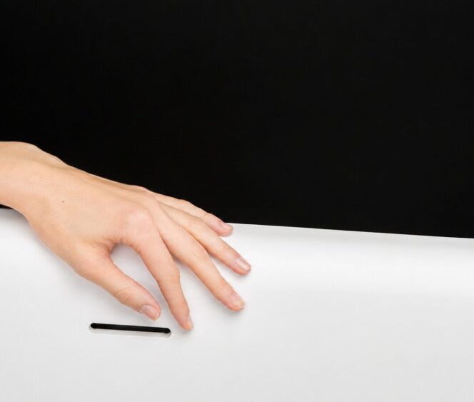 Naise käsi puudutamas valget Xonyx™ solid surface materjali.